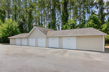 a row of garages in front of trees